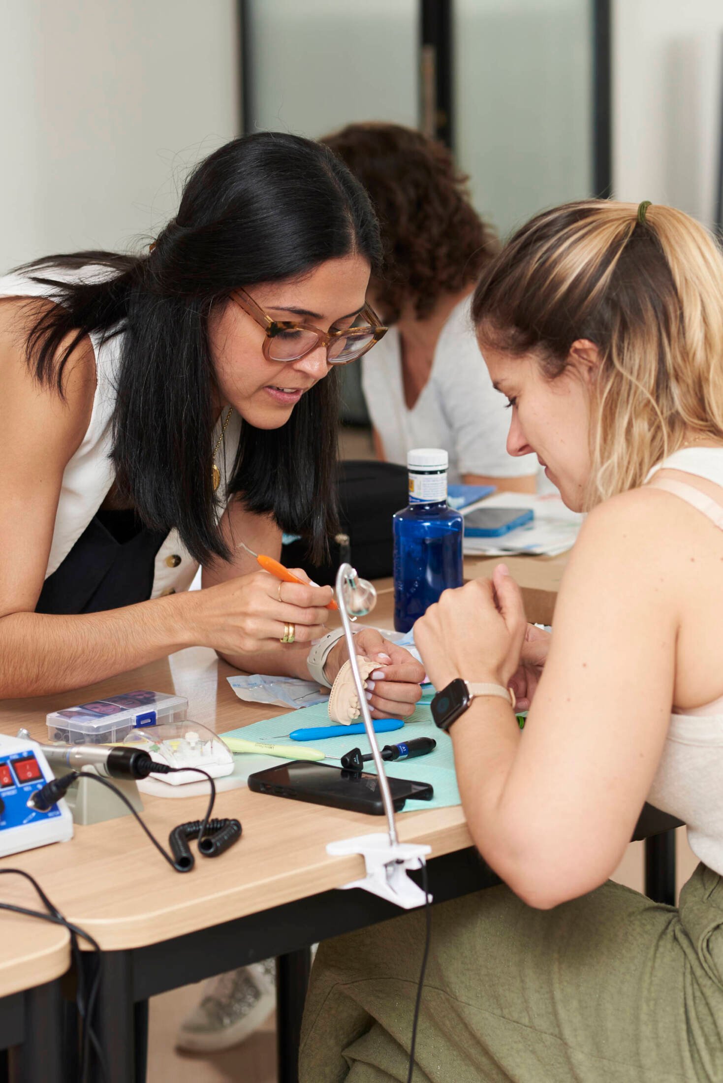 María Jesús explicando técnica de carillas de composite a participante durante práctica con modelo dental